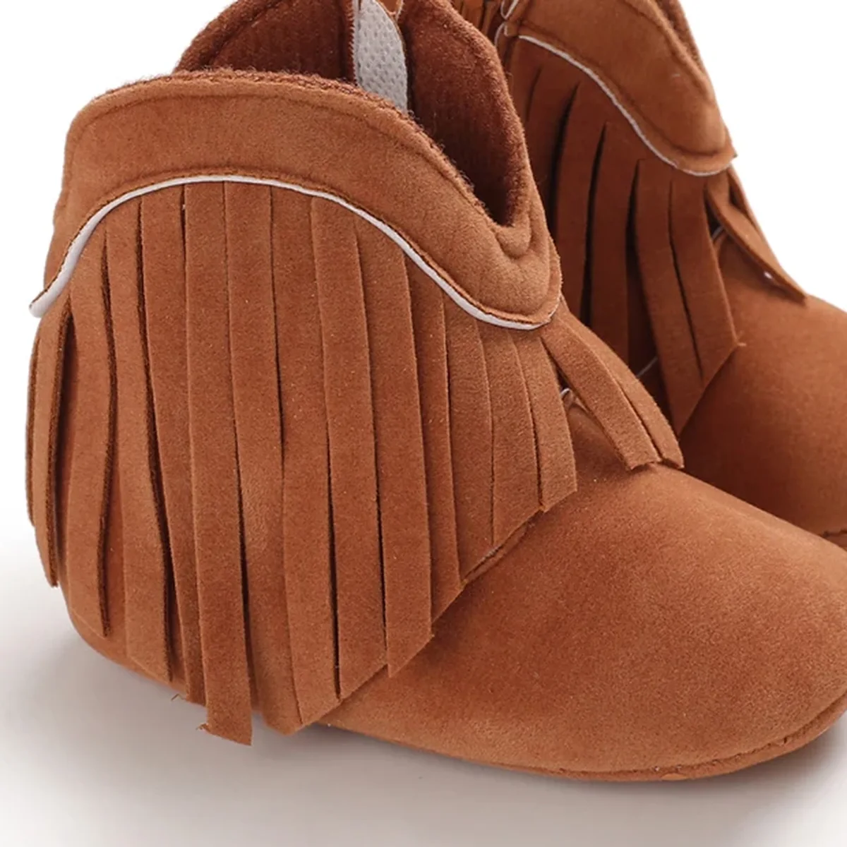 Détail des franges et du liseré des bottines bébé marron