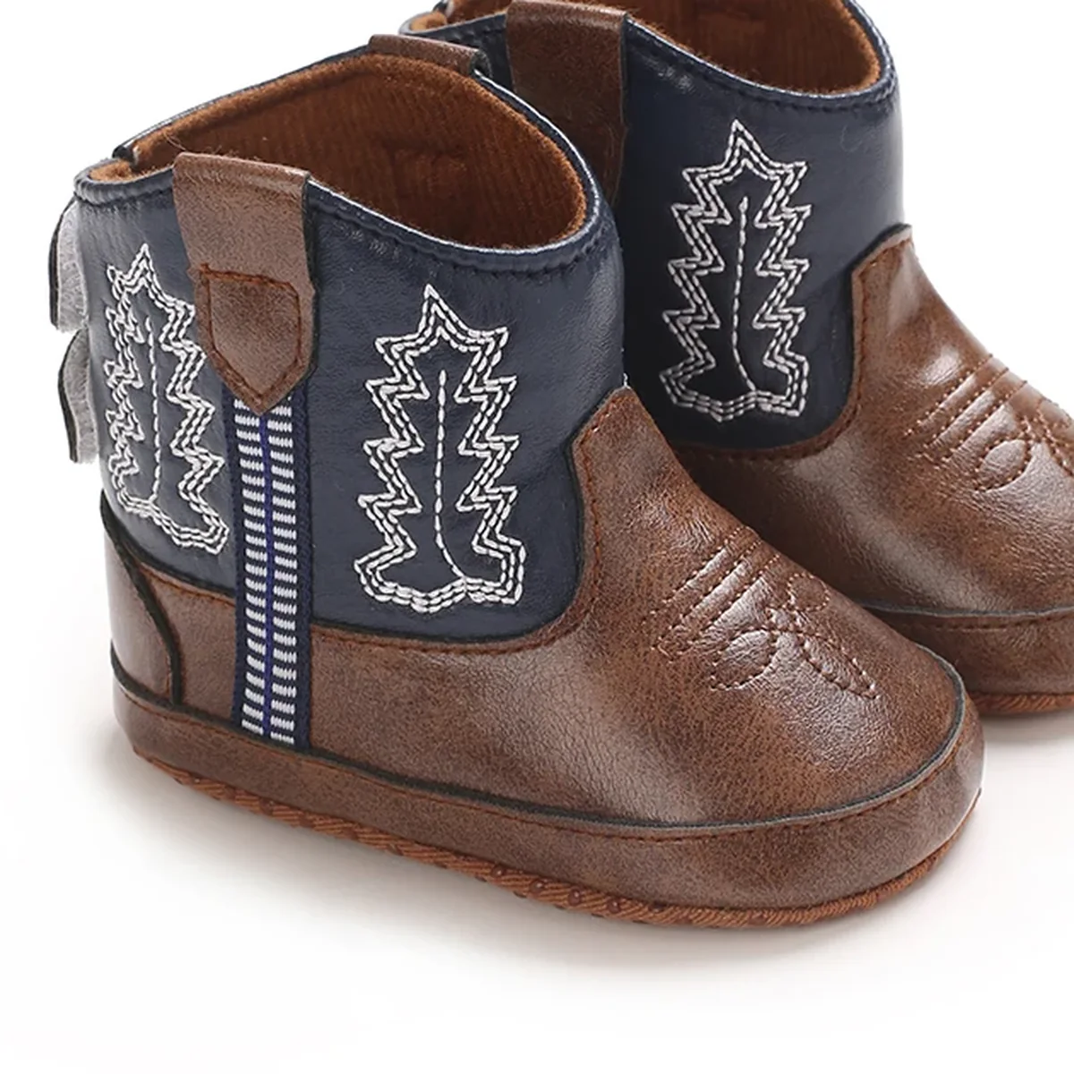 Détail de la feuille brodée sur la tige bleue des bottines bébé marron et bleu