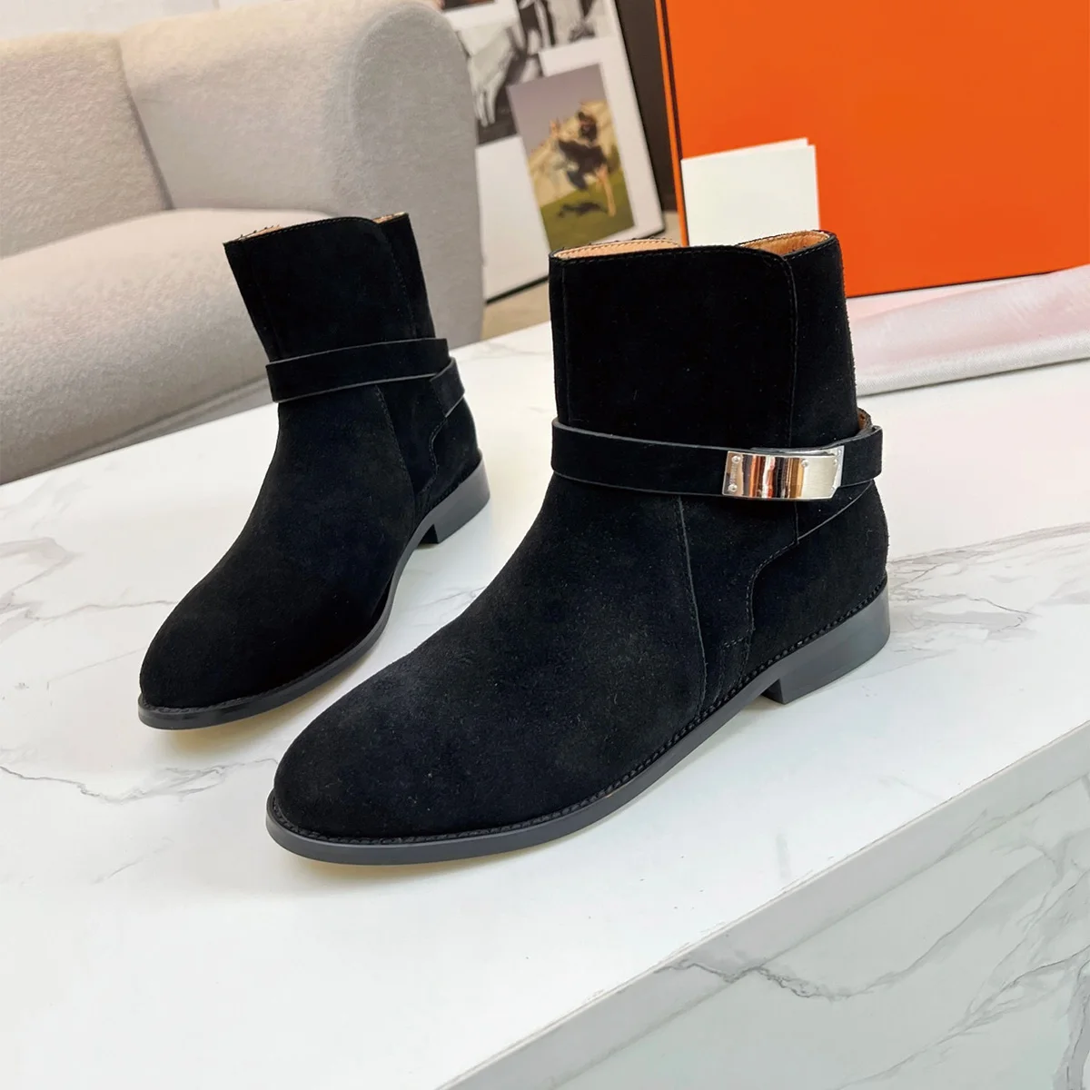 Vue latérale des bottines noires en velours avec détail métallique