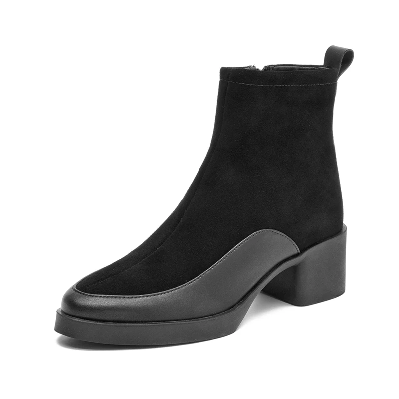 Femme portant des bottines noires à talon carré avec finition lisse