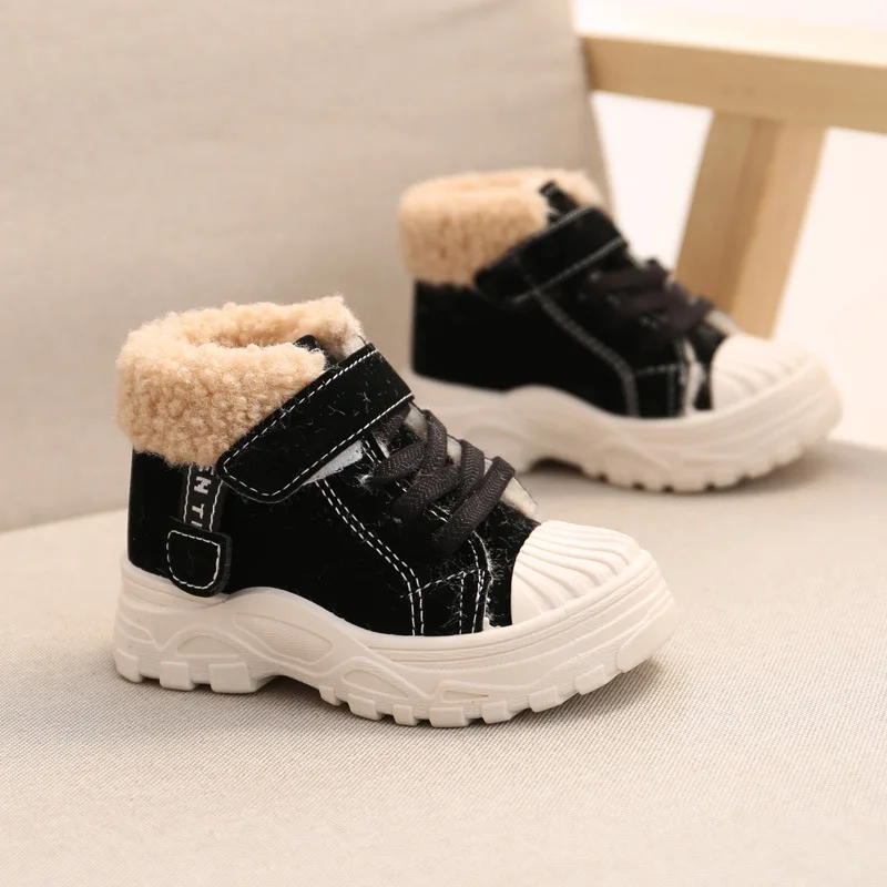 Bottines garçon noires fourrées à scratch et semelle claire en gros plan