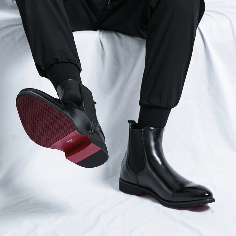 Homme portant des bottines Chelsea noires à semelle rouge stylées