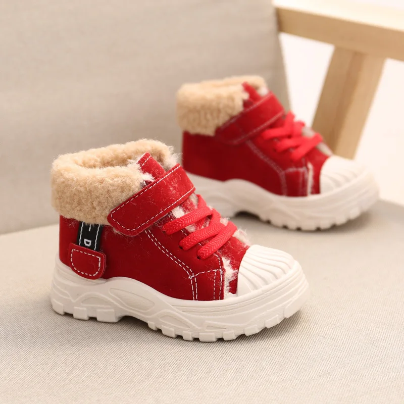 Enfant en bottines noires fourrées à scratch, mode hiver garantie