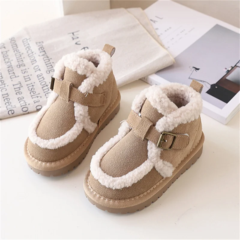 Petite fille portant des bottes de neige noires en cuir fourrées