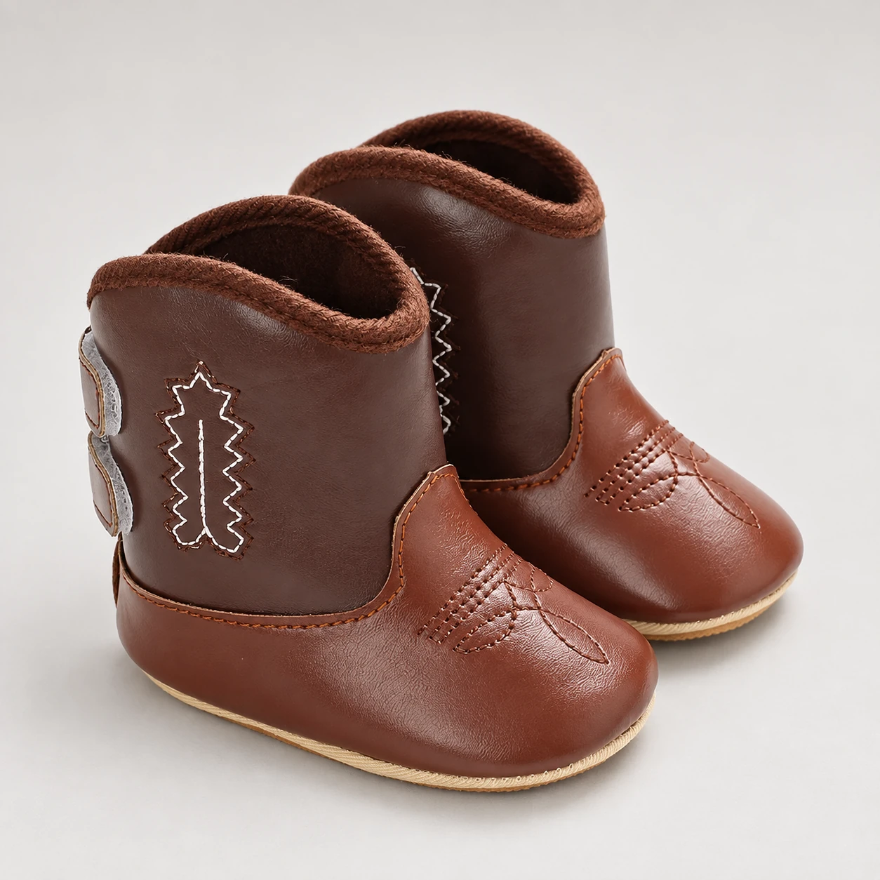 bottines bebe western marron bicolores a coutures decoratives presentation fond neutre