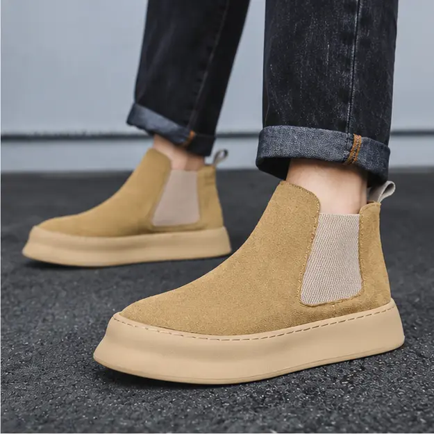 bottines chelsea homme beiges a semelle beige portees en marchant avec un pantalon sombre 45333
