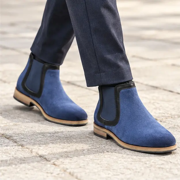 bottines chelsea homme bleues a finition mate portees en marchant avec un pantalon sombre 45364