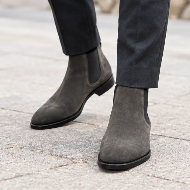 bottines chelsea homme grises en suedine portees en marchant avec un pantalon sombre 45376