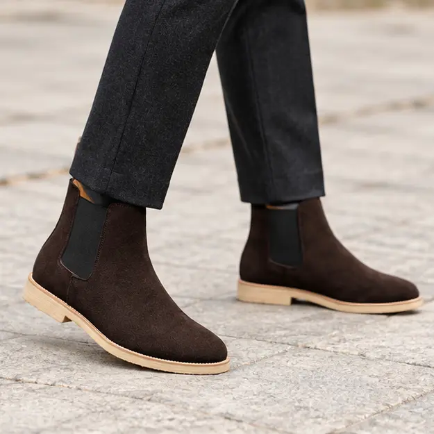 bottines chelsea homme marron a finition veloutee portees en marchant avec un pantalon sombre 45393