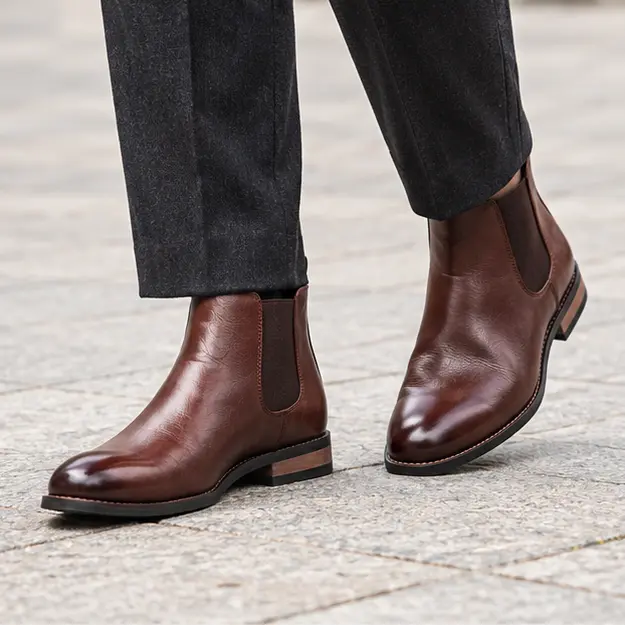 bottines chelsea homme marron a ligne lisse portees en marchant avec un pantalon sombre 45370