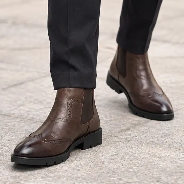 bottines chelsea homme marron a perforations decoratives portees en marchant avec un pantalon sombre 45422