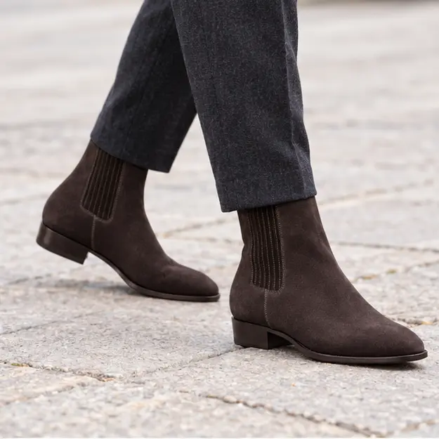 bottines chelsea homme marron fonce a bout effile portees en marchant avec un pantalon sombre 45381