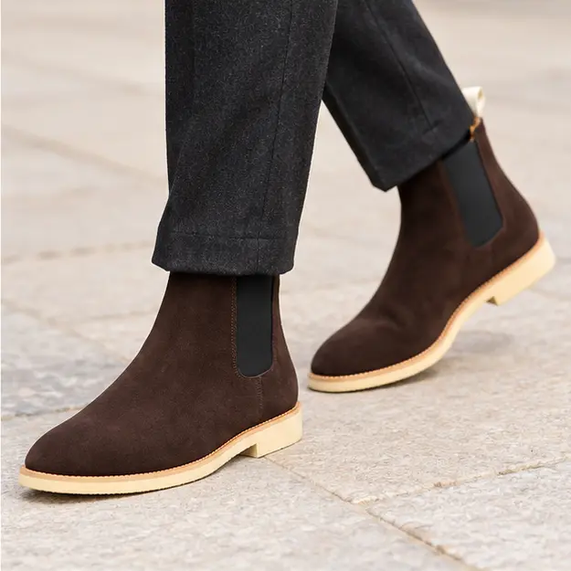 bottines chelsea homme marron fonce a semelle claire portees en marchant avec un pantalon sombre 45409