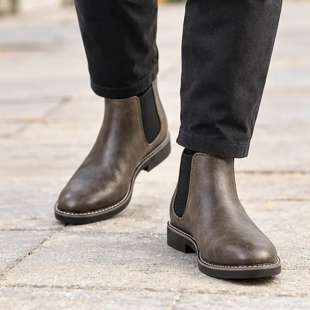 bottines chelsea homme marron taupe a elastiques noirs portees en marchant avec un pantalon sombre 45368