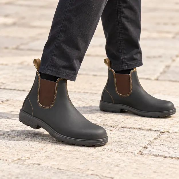 bottines chelsea homme noires a elastiques marron portees en marchant avec un pantalon sombre 45433