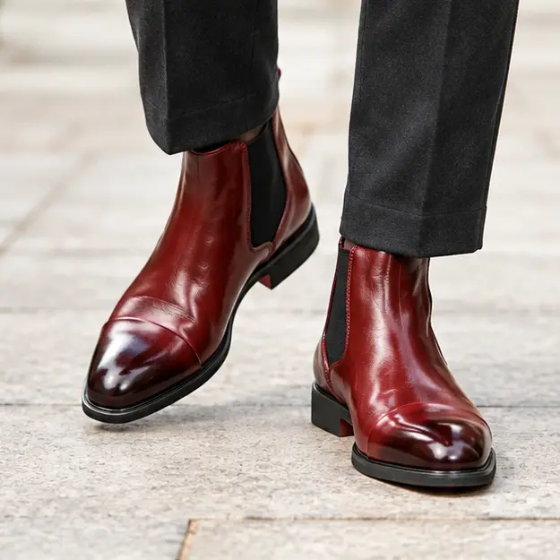 bottines chelsea homme rouges a semelle rouge portees en marchant avec un pantalon sombre 45404