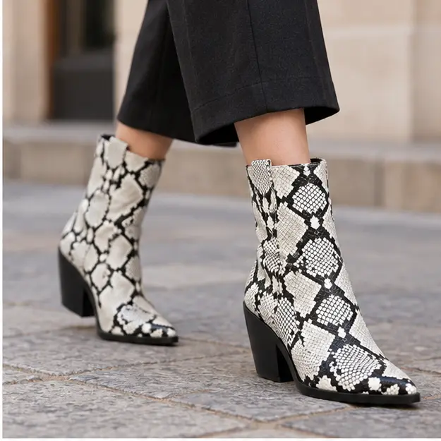 bottines cowboy femme blanches effet serpent portees en marchant avec un pantalon sombre 45203