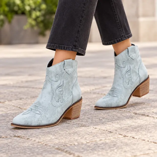 bottines cowboy femme bleu clair a broderies portees en marchant avec un pantalon sombre 45204