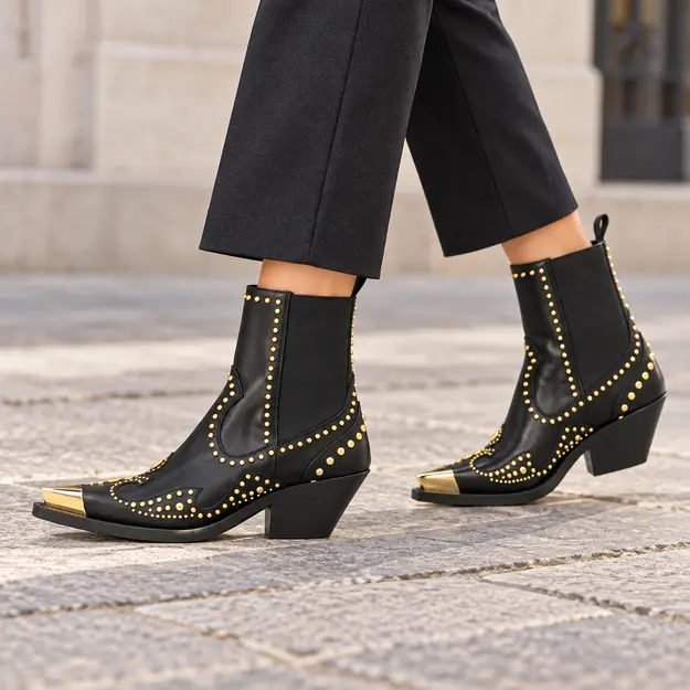bottines cowboy femme noires a details dores portees en marchant avec un pantalon sombre 45206
