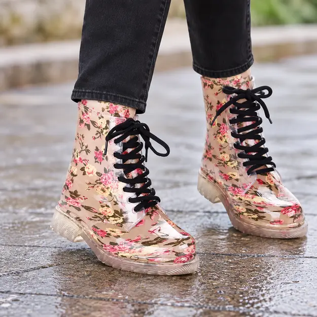 bottines de pluie femme beiges fleuries fantaisie portees en marchant avec un pantalon sombre 45175