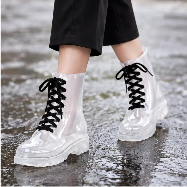 bottines de pluie femme blanches a lacets portees en marchant avec un pantalon sombre 45187