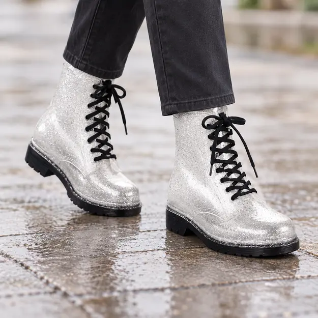 bottines de pluie femme blanches pailletees fantaisie portees en marchant avec un pantalon sombre 45176