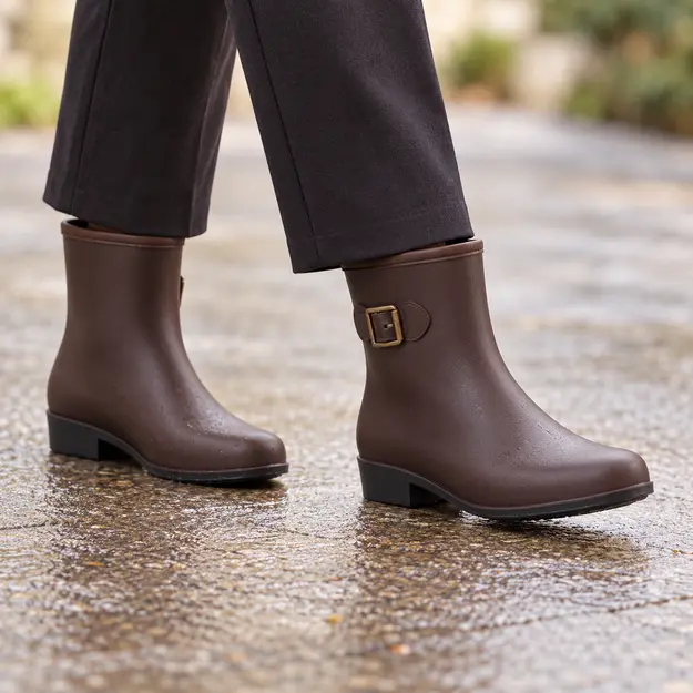 bottines de pluie femme marron a enfiler portees en marchant avec un pantalon sombre 45164