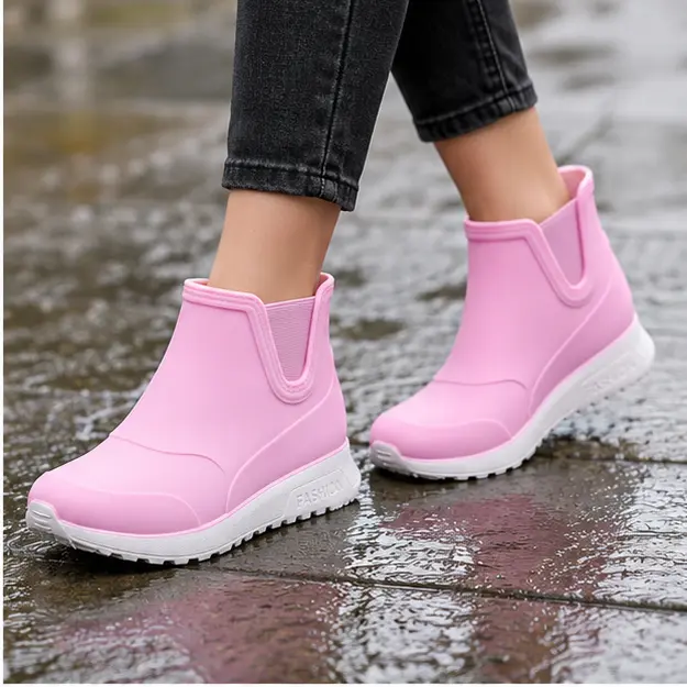 bottines de pluie femme roses fourrees portees en marchant avec un pantalon sombre 45181
