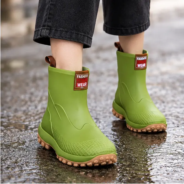 bottines de pluie femme vertes a semelle epaisse portees en marchant avec un pantalon sombre 45183