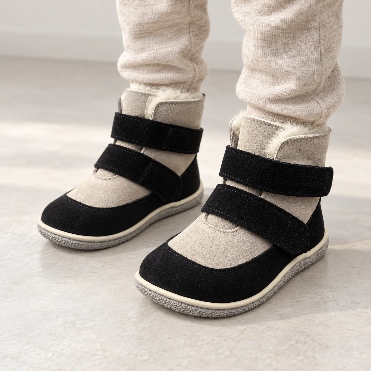 bottines enfant noires et grises fourrees a scratch portees par un enfant
