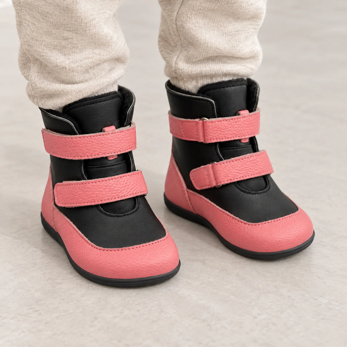 bottines enfant roses et noires a double scratch portees par un enfant