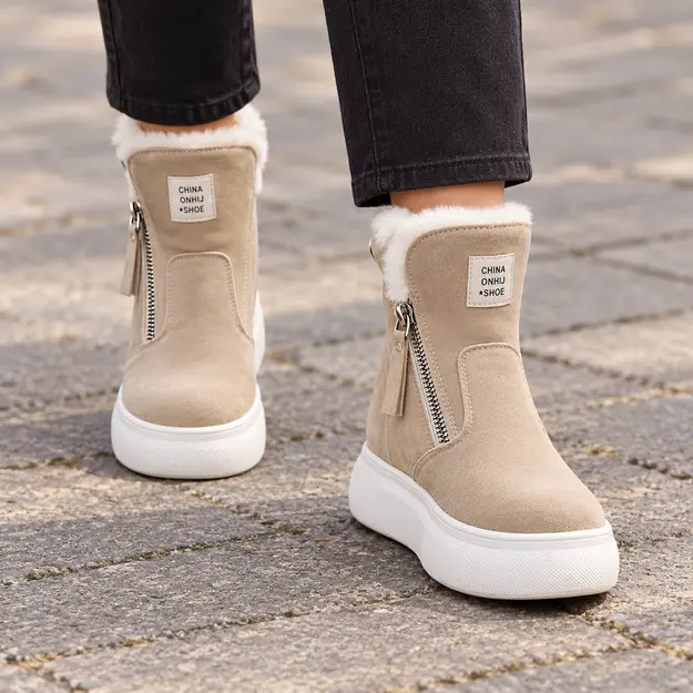 bottines femme beiges doublees a zip portees en marchant avec un pantalon sombre 45215
