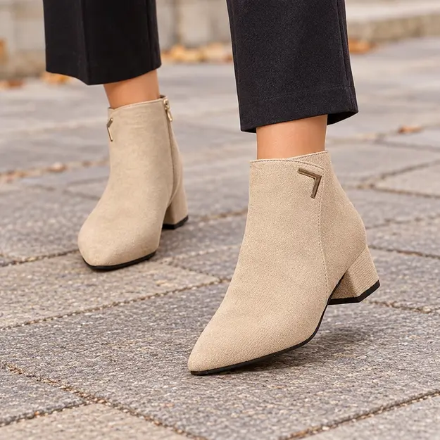 bottines femme beiges en suedine a talon carre portees en marchant avec un pantalon sombre 45224