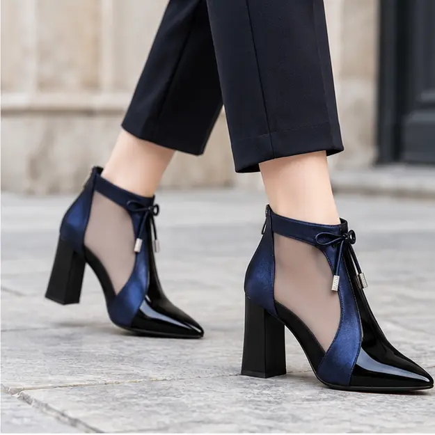 bottines femme bleues ajourees a haut talon portees en marchant avec un pantalon sombre 45227