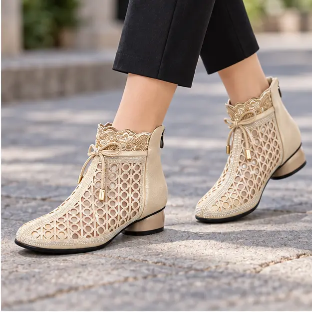 bottines femme dorees ajourees a zip portees en marchant avec un pantalon sombre 45234