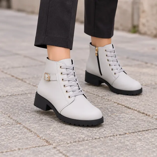 bottines femme grises a lacets et talon carre portees en marchant avec un pantalon sombre 45210