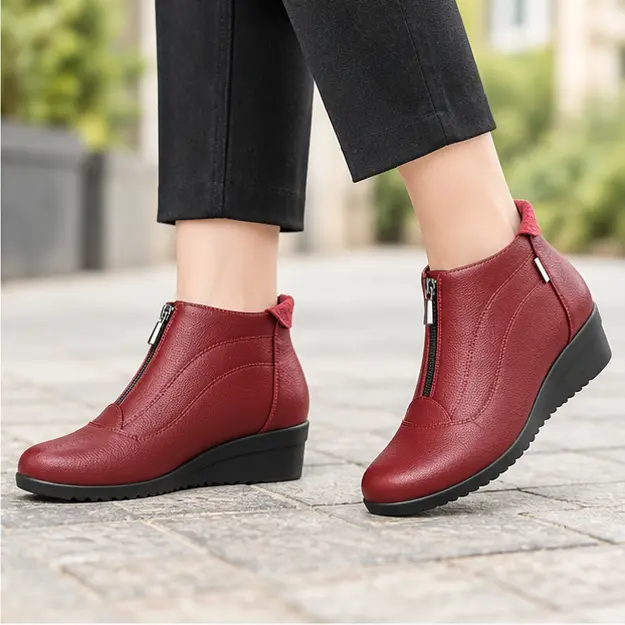 bottines femme rouges a talon compense portees en marchant avec un pantalon sombre 45238