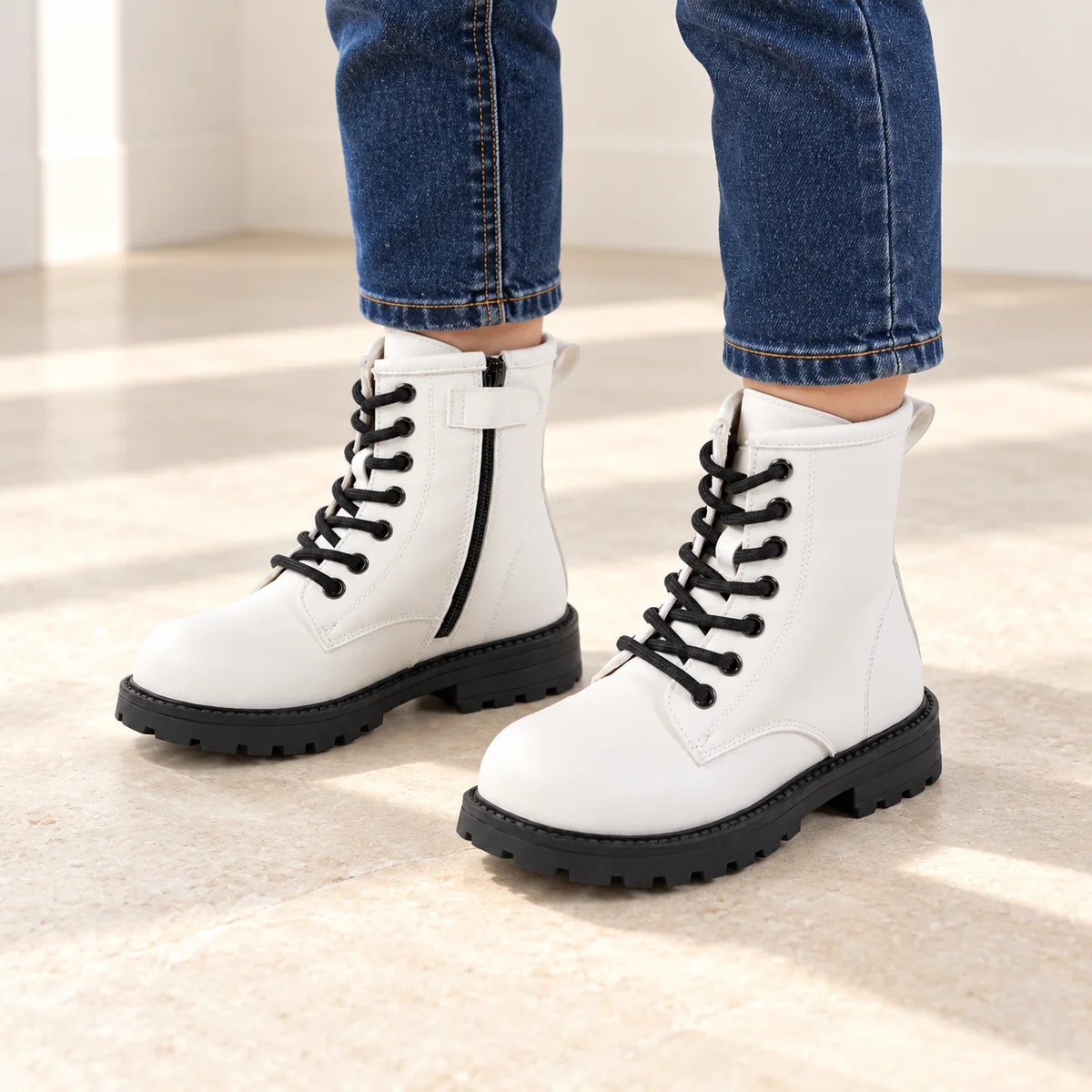 bottines fille blanches a lacets et semelle crantee portees par un enfant