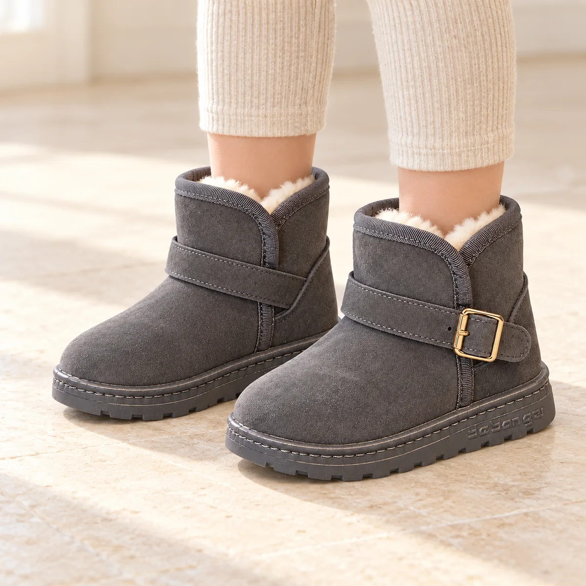 bottines fille grises fourrees a bride et boucle portees par un enfant