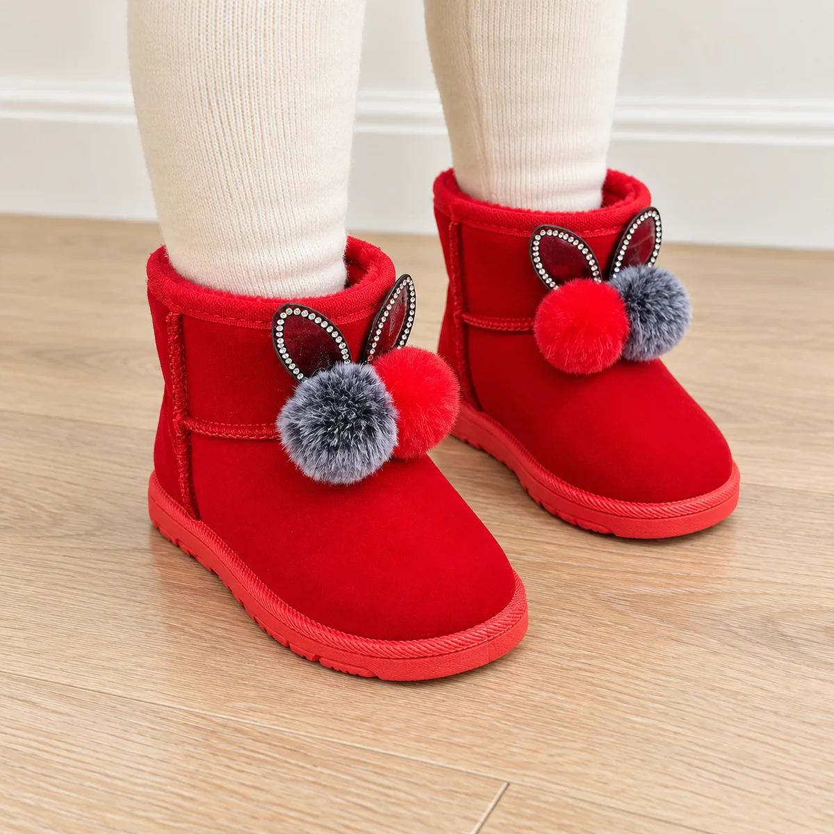 bottines fille rouges fourrees lapin a pompons portees par un enfant