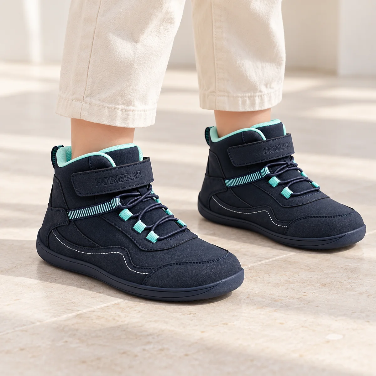 bottines garcon bleues a bout large et scratch portees par un enfant