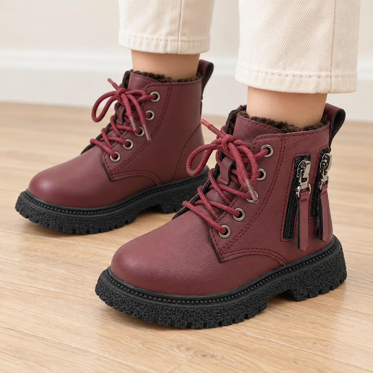 bottines garcon bordeaux fourrees a lacets et zips portees par un enfant