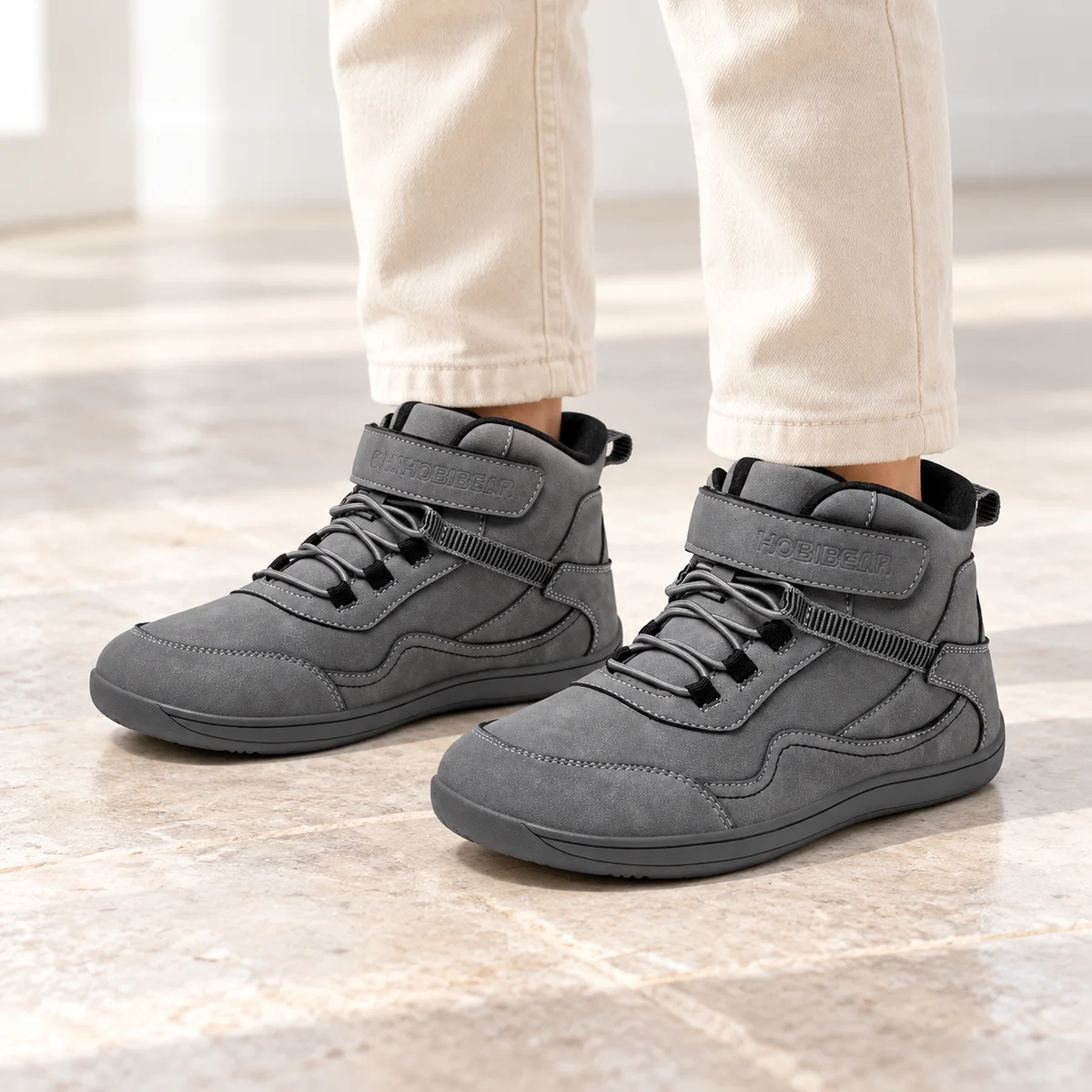 bottines garcon grises a bout large et scratch portees par un enfant