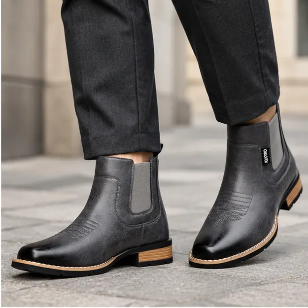 bottines homme grises sans lacets a surpiqures portees en marchant avec un pantalon sombre 45313