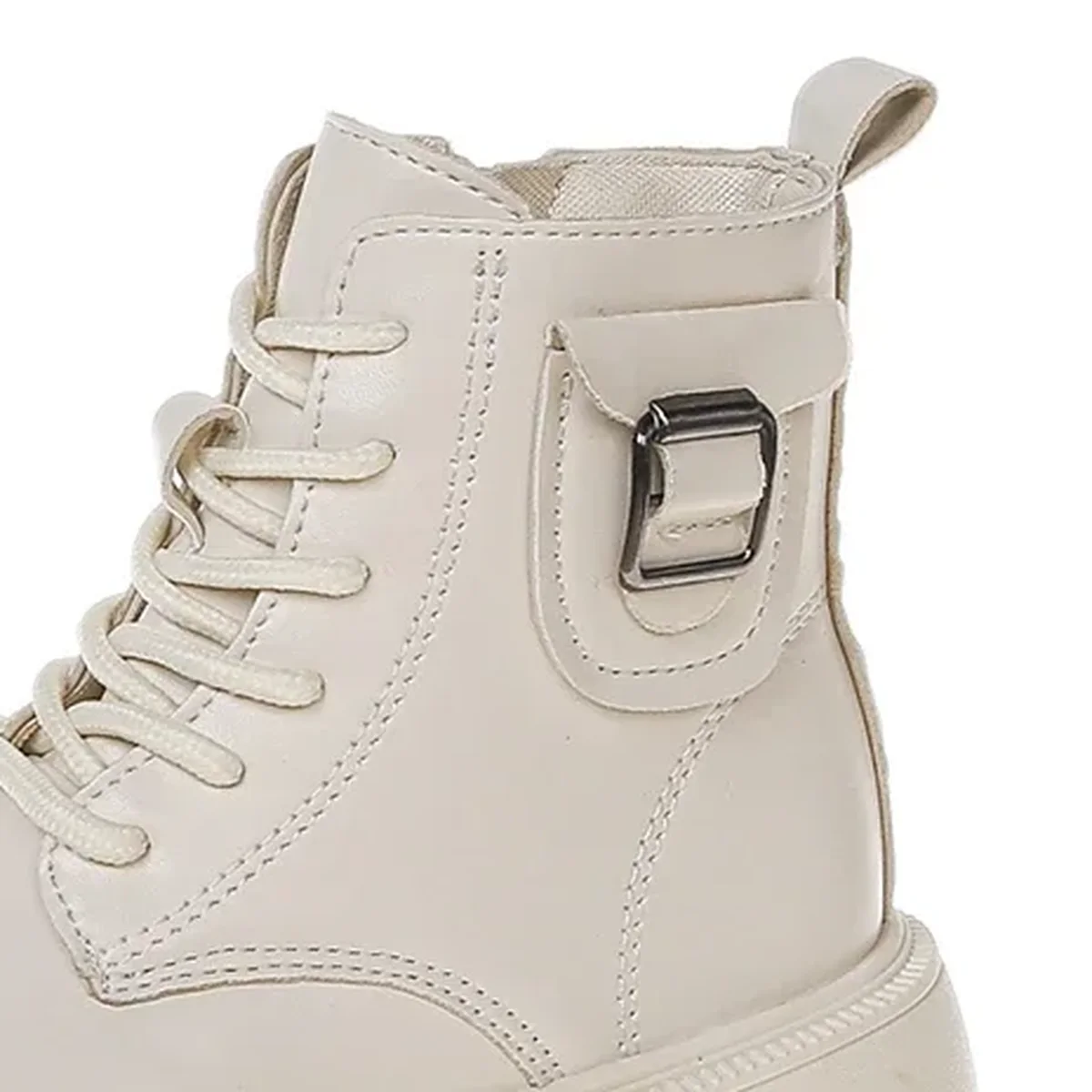 detail de la boucle et des coutures des bottines beiges a plateforme