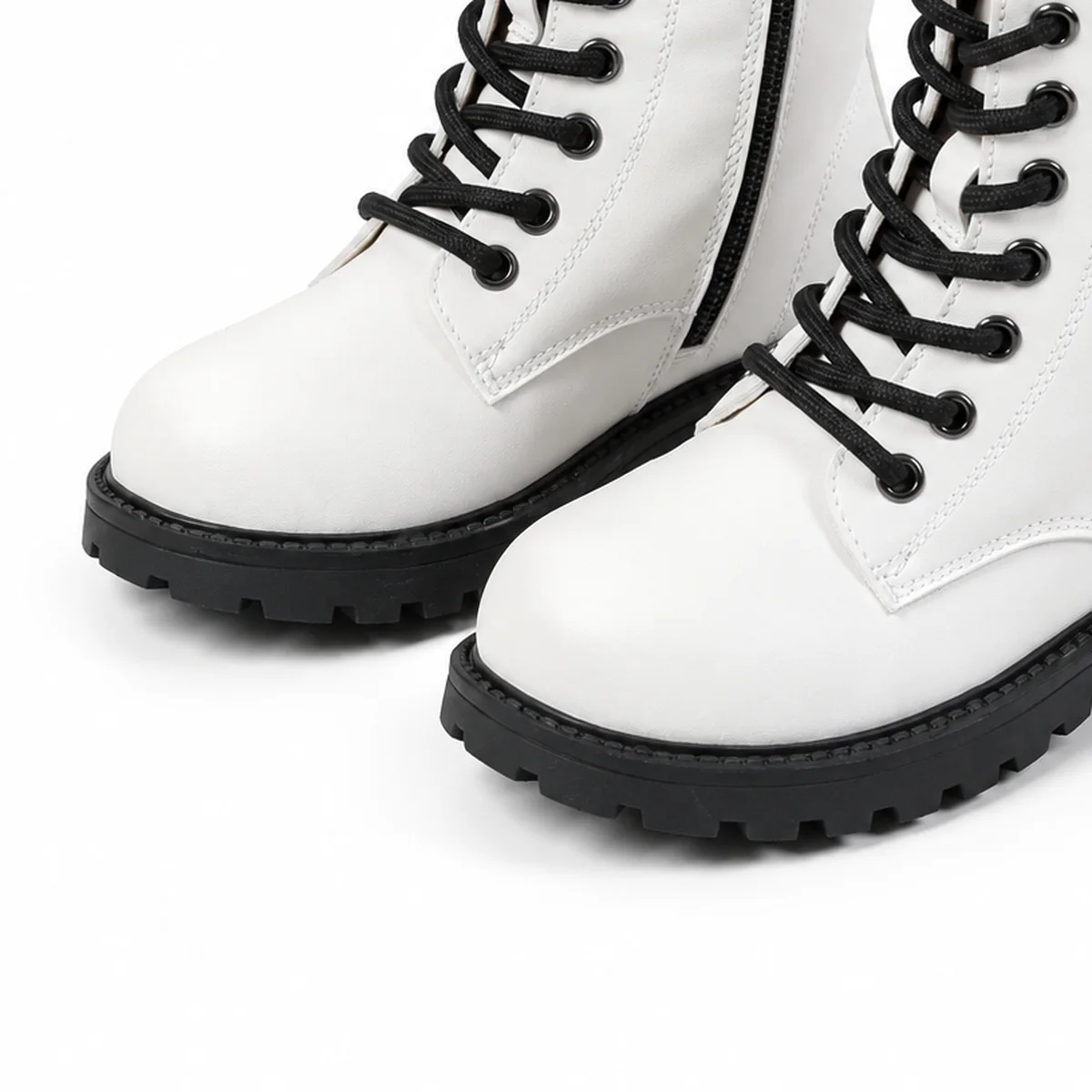 detail de la matiere et de la semelle des bottines fille blanches a lacets et semelle crantee
