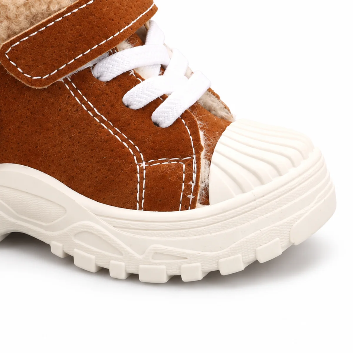 detail de la matiere et de la semelle des bottines garcon marron fourrees a lacets et scratch