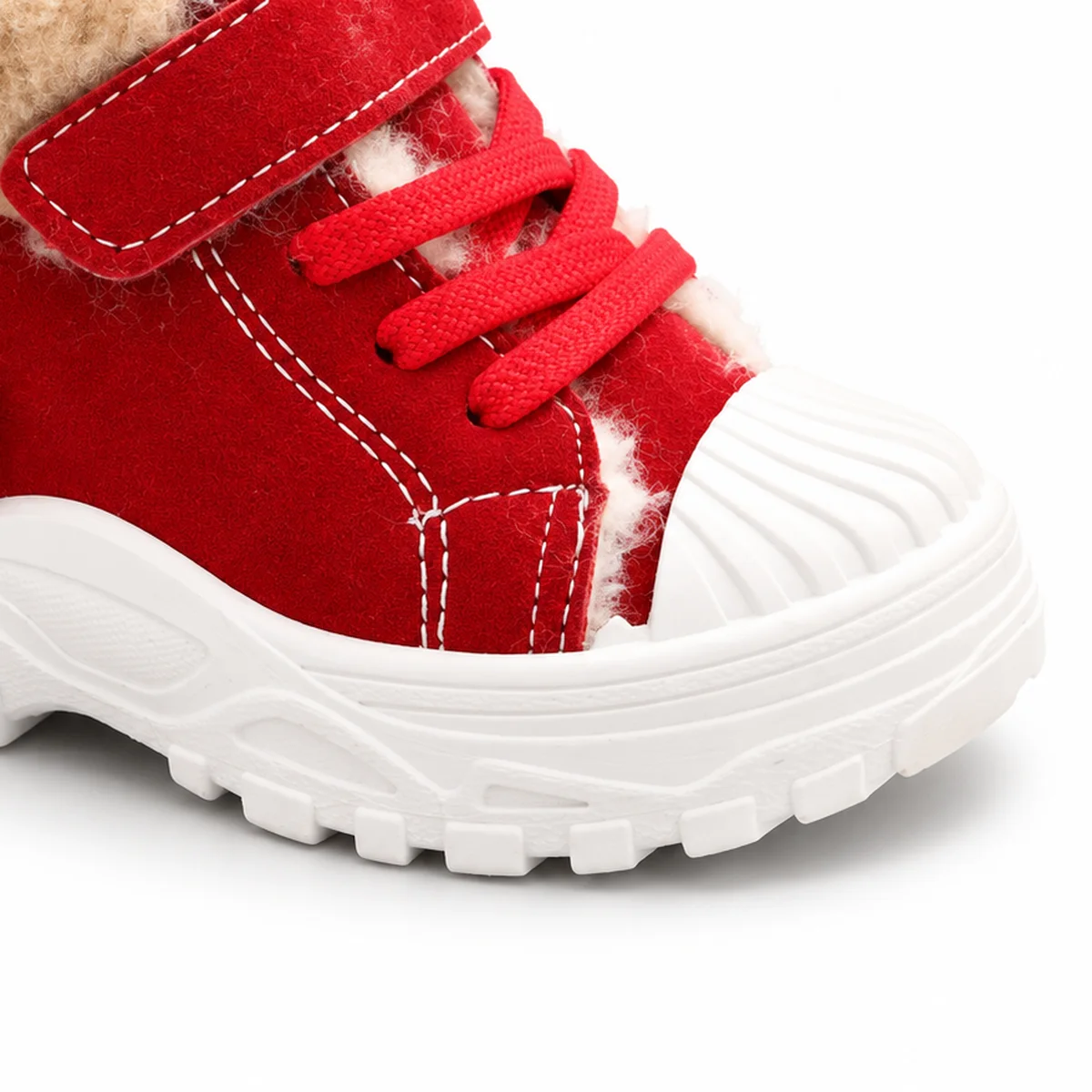 detail de la matiere et de la semelle des bottines garcon rouges fourrees a lacets et scratch