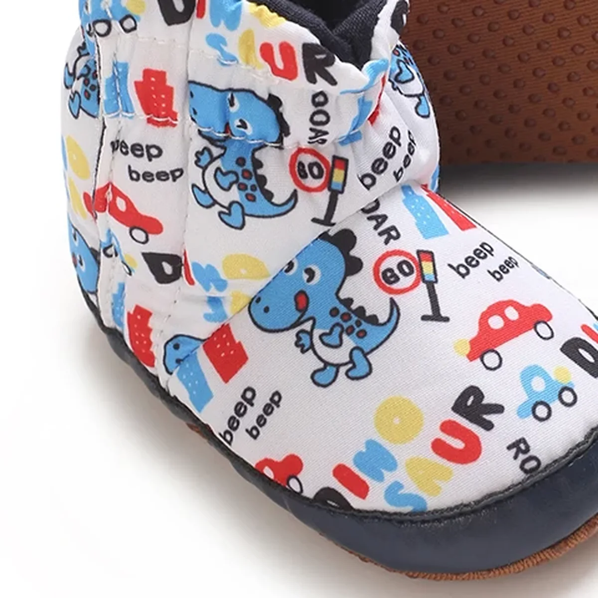 detail du bout et de la semelle des bottines bebe blanches a dinosaures colores et scratch