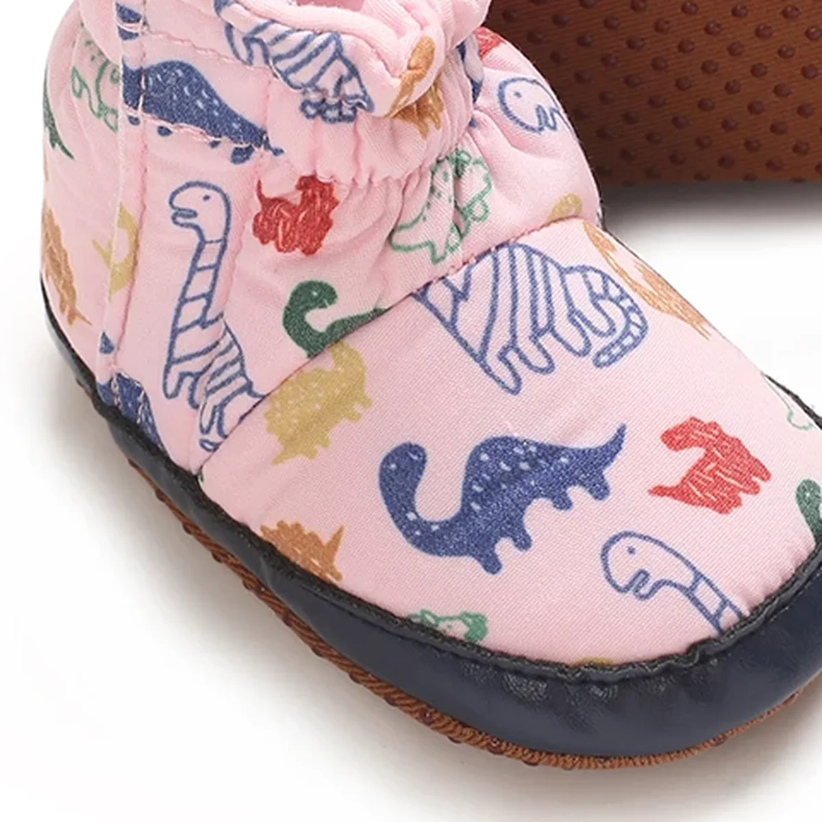 detail du bout et de la semelle des bottines bebe roses a motif dinosaure et scratch